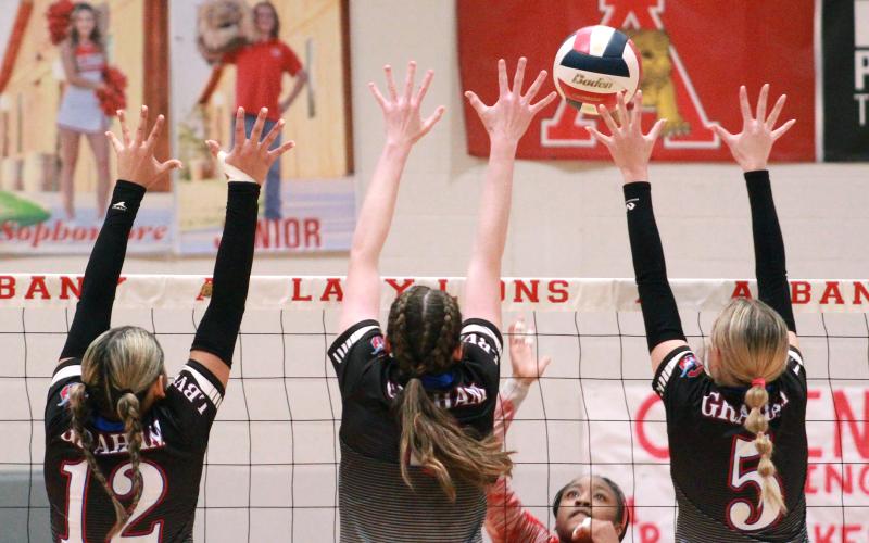 (TC GORDON | THE GRAHAM LEADER) Senior Olga Morales (12), junior Emilee Gordy (middle) and Braylee Mayes (5) create a wall of blockers for Graham during the team’s bi-district championship match Monday, Oct. 30 against Sweetwater. The Lady Blues defeated the Lady Mustangs in four sets and will move forward in the playoffs.