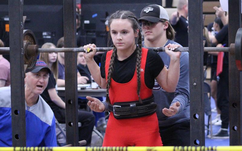 (TC GORDON | THE GRAHAM LEADER) Graham’s Mariah Frost prepares and sets herself up to do her squat lift during a powerlifting competition earlier this season. The Lady Blues competed in the Last Chance Qualifier at Weatherford last Thursday, Feb. 15.