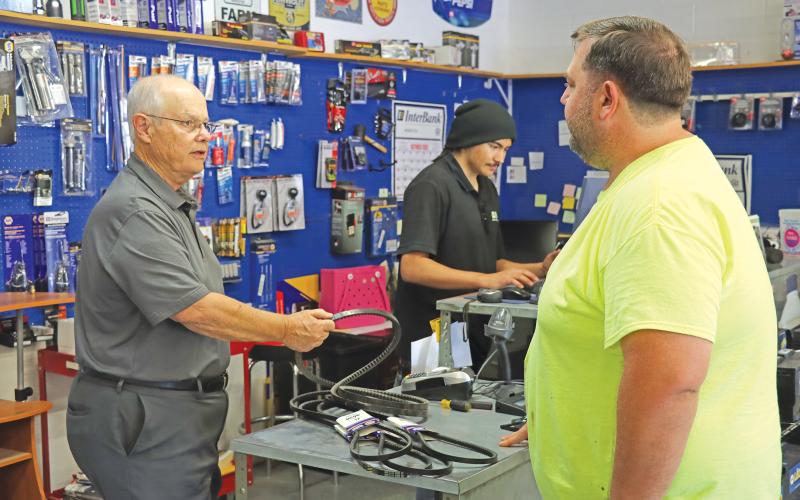 (THOMAS WALLNER | THE GRAHAM LEADER) Derrell Smith (at left), who owned and operated Gramco/NAPA Auto Parts in Graham for 50 years, speaks with a customer at the store. Smith sold the business to Mahlan LeBlanc, who took over operation of the store at the beginning of October.