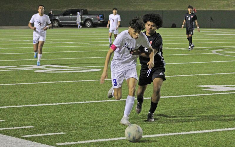 (TC GORDON | THE GRAHAM LEADER) Graham’s Jesus Lucio tries to break away from an Old High defender holding him during a match between the two teams Tuesday, Feb. 27. The Steers tied with the Coyotes 2-2 in regulation, but fell in penalty kicks 6-5.