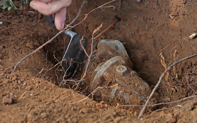 (THOMAS WALLNER | THE GRAHAM LEADER) A researcher with the Texas Tech uncovers a sconce buried by a gravesite at the Oak Grove Colored-William P. Johnston Memorial Cemetery. 