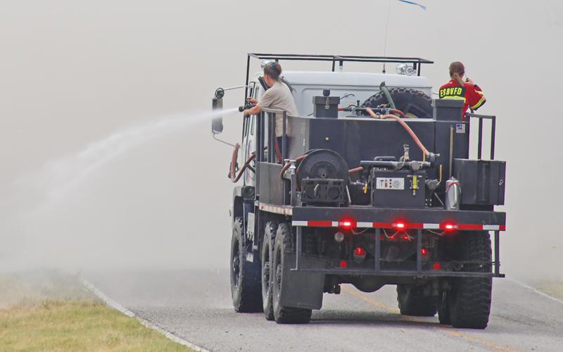 (THE GRAHAM LEADER | ARCHIVE PHOTO) Members of the Eliasville/South Bend Volunteer Fire Department spray water July 14, 2022 on what would later be called the South Bend Fire.