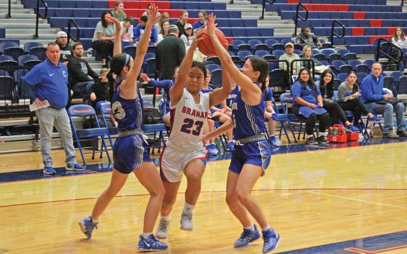 (TC GORDON | THE GRAHAM LEADER) Graham’s Rebecca McGregor splits two Childress defenders as she drives through for a contested layup during the Lady Blues’ 47-21 loss Thursday, Dec. 28 to the visiting Lady Bobcats.