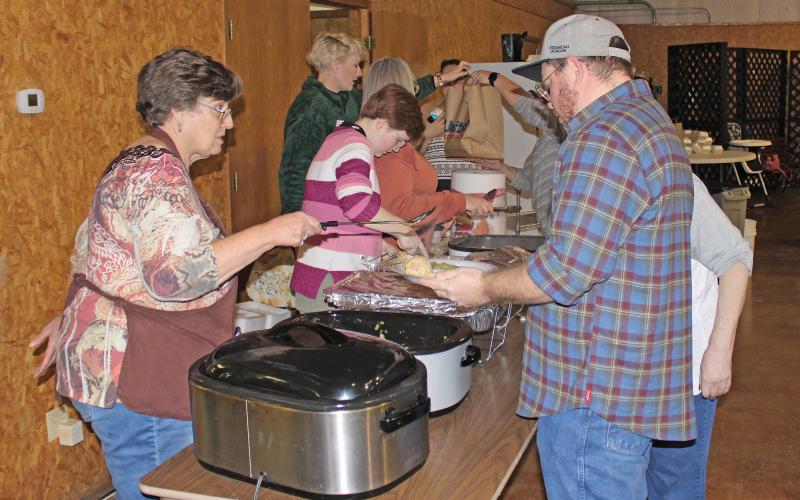 (FILE PHOTO | THE GRAHAM LEADER) Volunteers at the 2022 community Thanksgiving event hand out food to those in attendance. The 36th annual event this year will be held from noon to 1:30 p.m. Thursday, Nov. 23 at the Bethel Baptist Church Family Life Center at 209 Tennessee St. in Graham.