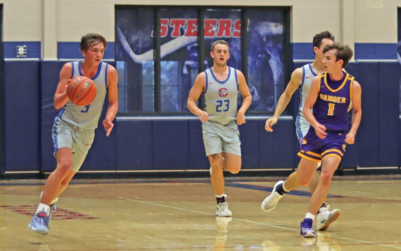 (THOMAS WALLNER | THE GRAHAM LEADER) Tyson Weaver (3) brings the ball up the court while teammates work to get open during Graham’s match-up Tuesday, Nov. 21 against the Sanger Indians. The Steers put up a fight but took the close loss 60-58.