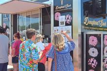 (THE GRAHAM LEADER | ARCHIVE PHOTO) Visitors to the 2022 Food Truck Championship of Texas look over menu items at the Doughnut Snob food truck. The Graham City Council will be hosting a public hearing after a local food truck reached out to request access to the downtown square.