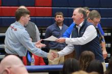 (TC GORDON | THE GRAHAM LEADER) New head football coach and athletic director Clay McChristian (right) presents an award to a Graham football player during the fall sports banquet held Monday, Jan. 15. McChristian had been serving as defensive coordinator before being appointed to the new positions Wednesday, Jan. 17.