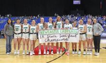 (TC GORDON | THE GRAHAM LEADER) The Newcastle Ladycats pose with their state semifinal banner after defeating Westbrook 59-37 to advance to the state title game. The Ladycats will play Saturday, March 2 for the state title.