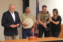 (THOMAS WALLNER | THE GRAHAM LEADER) Chaplin Gary Elrod leads a prayer at a service held Friday, July 28 for Sam, a K9 unit at the Young County Sheriff’s Office which died Wednesday, June 21. Shown from left to right are Elrod, YCSO Sheriff Travis Babcock, Sam’s K9 Handler Alex Maiden and Simone Maiden.