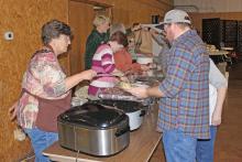 (FILE PHOTO | THE GRAHAM LEADER) Volunteers at the 2022 community Thanksgiving event hand out food to those in attendance. The 36th annual event this year will be held from noon to 1:30 p.m. Thursday, Nov. 23 at the Bethel Baptist Church Family Life Center at 209 Tennessee St. in Graham.