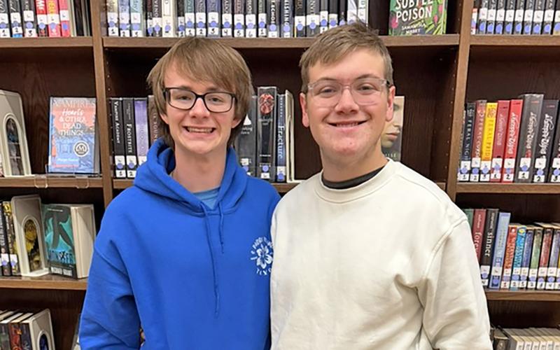 (STEPHANIE TALBOTT | CONTRIBUTED PHOTO) Graham High School students Ryder Calhoun (left) and Christopher Stroud pose for a photo in the GHS library. Calhoun will be attending Rice University after utilizing QuestBridge.
