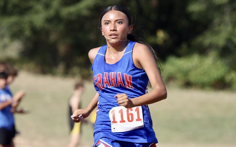(KYLIE BAILEY | THE GRAHAM LEADER) 	Angela Fuentes makes her way around the girls 3.2K run Wednesday, Sept. 17. The Lady Blues and Steers participated in the Battle of the Back 40 in Poolville.