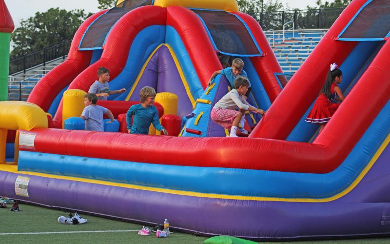 (ALEX HAVARDANSKY | THE GRAHAM LEADER) Children play on one of the bounce houses set up on Newton Field during the booster bash Monday, Aug. 11. This was one of several bounce houses set up for the kids. 