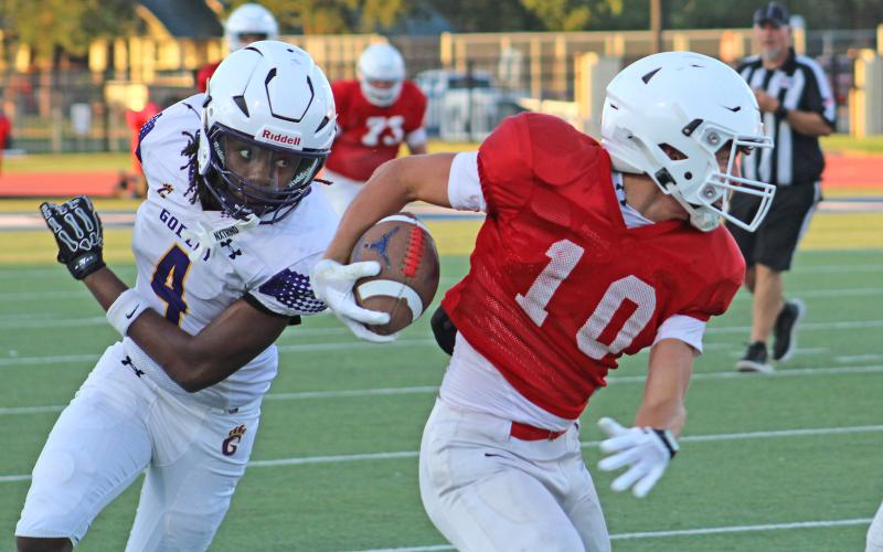 (ALEX HAVARDANKSY | THE GRAHAM LEADER) Brodie Martin runs past two defenders Thursday, Aug. 21, against Godley. Martin caught two more touchdowns for Graham in this scrimmage.