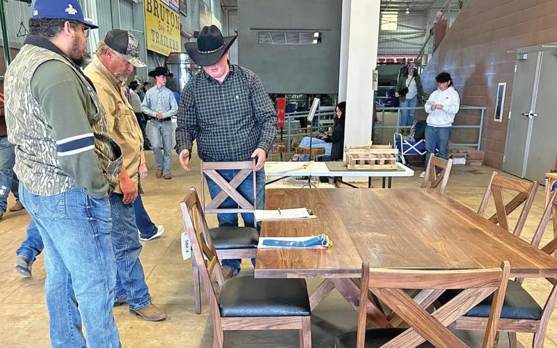 (GRAHAM FFA | CONTRIBUTED PHOTO) Lance Browning shows off his wood kitchen table with chairs at the Ag Mechanics contest in the San Angelo Stock Show & Rodeo.
