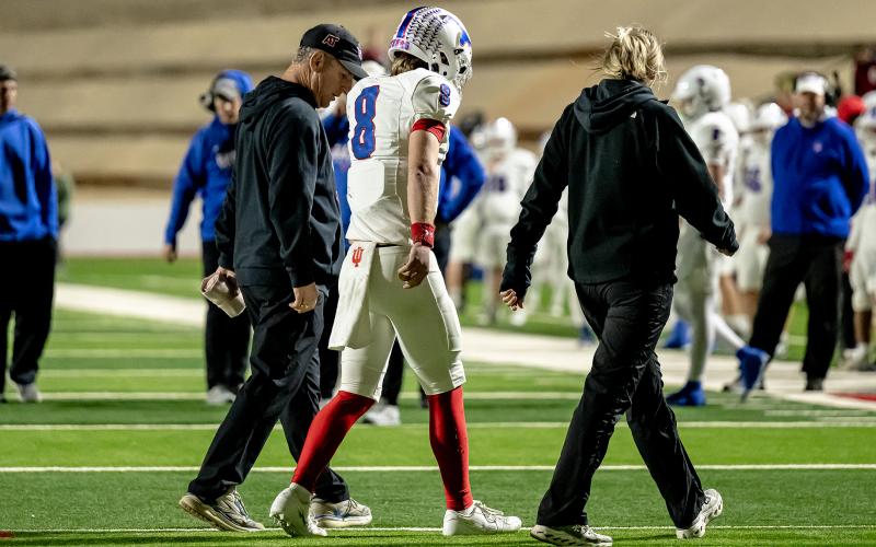 (DAVID FLYNN | CONTRIBUTED PHOTO) Graham athletic trainer in Mike Carroll walks off the field with Jace Gill during a Steers game against the Midland Greenwood Rangers in November 2025.