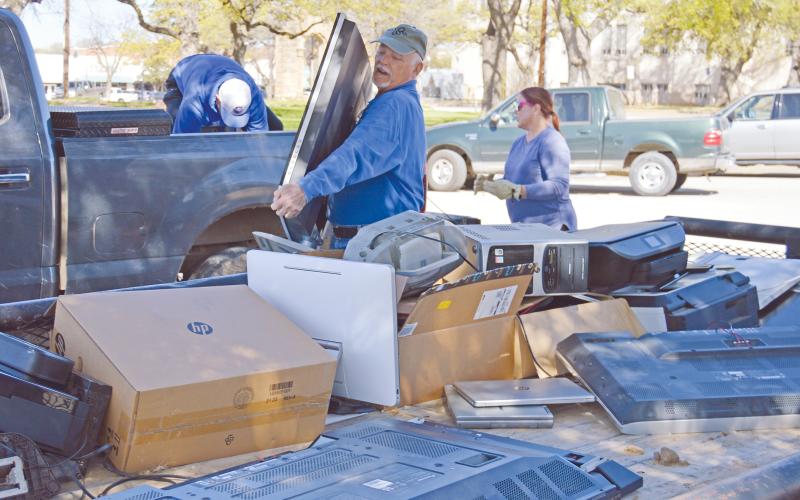 (ARCHIVE PHOTO | THE GRAHAM LEADER) JW Budge lifts a television into the back of a trailer to be recycled during the 2023 spring clean up event. The event this year will kick off Saturday, April 5.