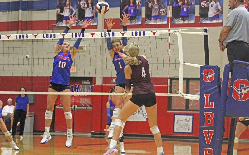 (ALEX HAVARDANKSY | THE GRAHAM LEADER) Emily Hughes, 10, and Katy McGehee, 1, go up for a block Tuesday, Sept. 23. The Lady Blues held their senior night match against the Brownwood Lady Lions this night.