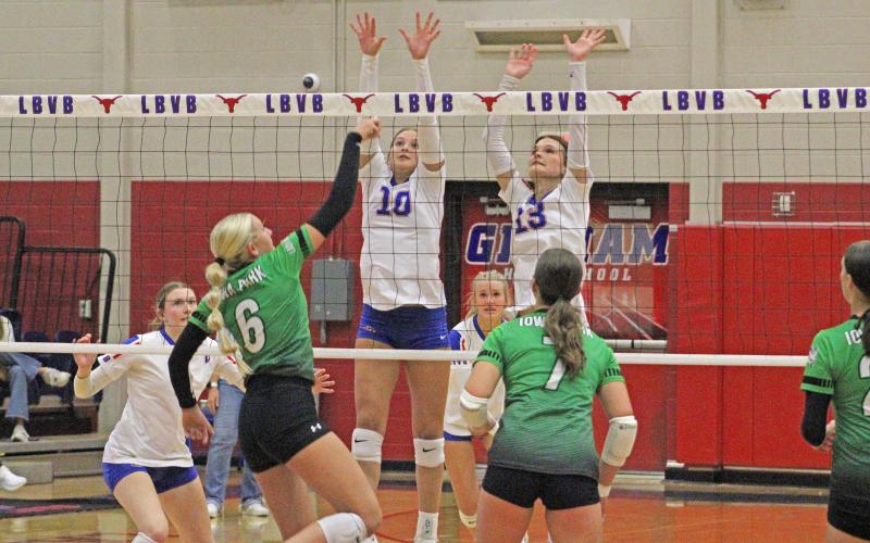 (ALEX HAVARDANKSY | THE GRAHAM LEADER) Emily Hughes (left) and Tara Dawson (right) go up for a block at center net for the Lady Blues. The Lady Blues won a thrilling five set game against the Iowa Park Lady Hawks. 