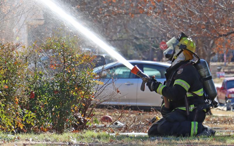 (THOMAS WALLNER | THE GRAHAM LEADER) A Graham Fire Department firefighter sprays water at a home on the corner of Plum and Second Street. GFD and other adjoining county fire departments received grants from the Texas A&M Forest Service in February for equipment and training aids.