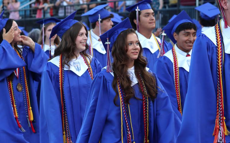 (THOMAS WALLNER | THE GRAHAM LEADER) Graham High School Class of 2026 graduates walk the track at Newton Field as visitors cheer them on from the stands during the beginning of the graduation ceremony held Friday, May 22.