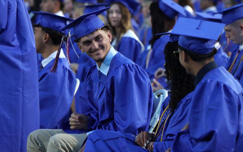 (THOMAS WALLNER | THE GRAHAM LEADER) Graham High School graduate Jordan Alexander smiles at a classmate during the graduation ceremony held Friday, May 22 at Newton Field.