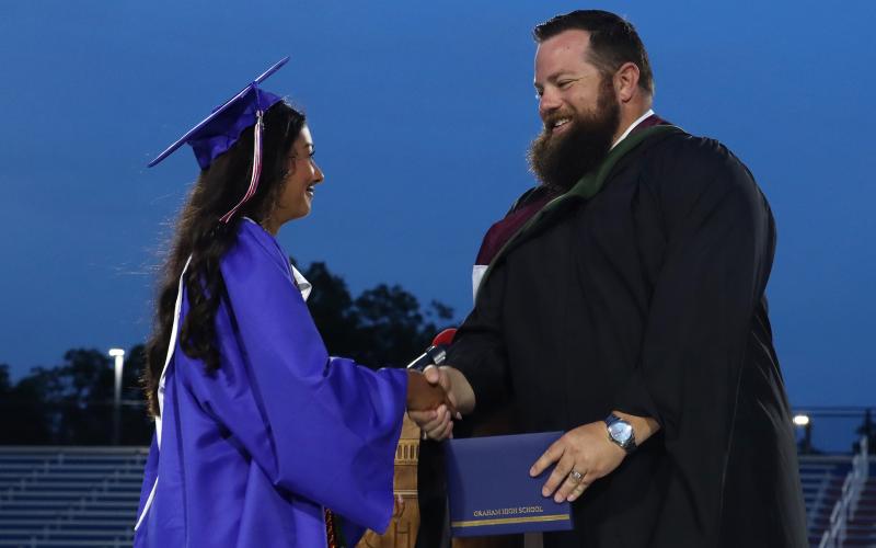 (THOMAS WALLNER | THE GRAHAM LEADER) Graham High School graduate Mai Bara shakes hands with Principal Adam Anderson as she receives her diploma during the graduation ceremony held Friday, May 22.