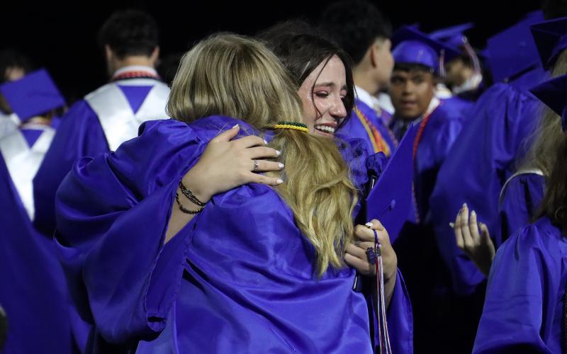 (THOMAS WALLNER | THE GRAHAM LEADER) Graham High School graduate Kambrey Moore hugs a classmate following the conclusion of the graduation ceremony Friday, May 22.