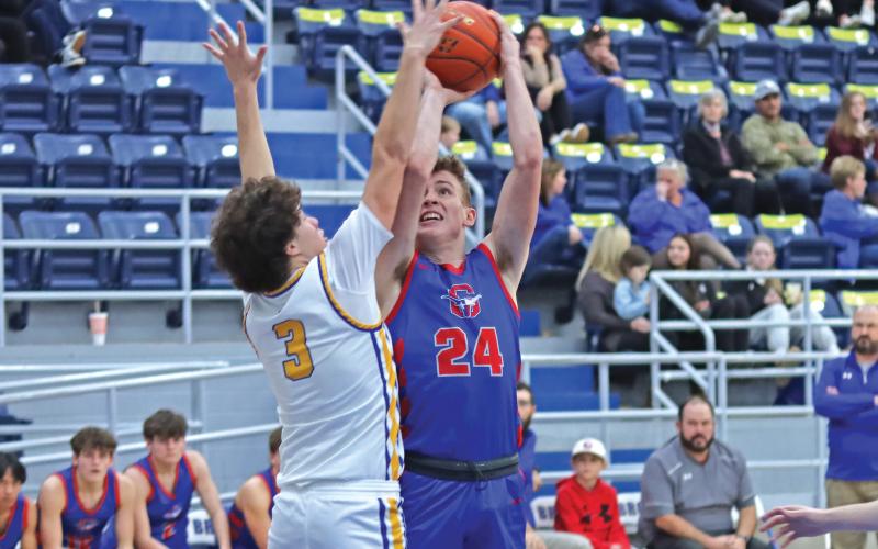 (THOMAS WALLNER | THE GRAHAM LEADER) Thomason Burkett jumps to attempt a shot over a Brock defender during the Steers district opener Saturday, Jan. 11. The game was moved to Saturday after school was canceled due to inclement weather.