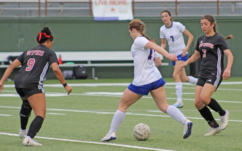 (TC GORDON | THE GRAHAM LEADER) Graham freshman Adi Pinkston dribbles the ball through two Old High defenders during the Lady Blues’ 6-1 loss to the Lady Coyotes this past Tuesday, Feb. 27.