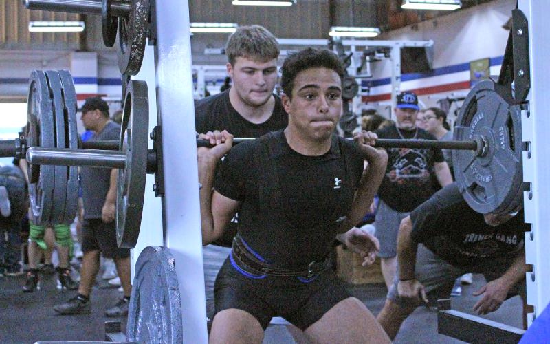 (TC GORDON | THE GRAHAM LEADER) Graham’s Stian Tunstroem keeps his focus while executing his squat lift during a powerlifting event held in the GHS field house Thursday, Feb. 1.