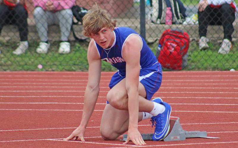(TC GORDON | THE GRAHAM LEADER) Graham’s Thomason Burkett sets his feet on the blocks and watches the starter before the 400-meter Dash Monday, April 1 at the District 6-4A track meet in Mineral Wells.