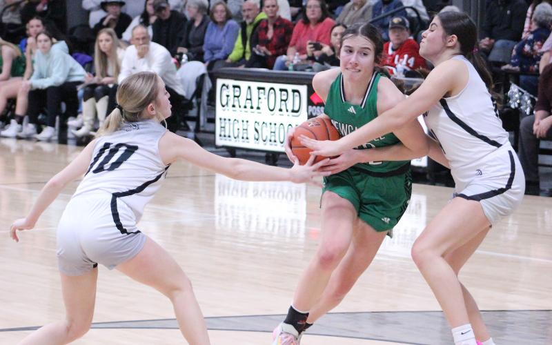 (TC GORDON | THE GRAHAM LEADER) Newcastle’s Mattie Dollar splits two Graford defenders on a drive to the hoop during the Ladycats’ 60-37 district win Tuesday, Jan. 23 over the Lady Rabbits.