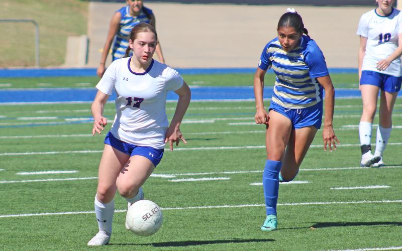 (TC GORDON | THE GRAHAM LEADER) Graham’s Adi Pinkston escapes from defenders and begins to move the ball upfield looking for an opportunity to score during the team’s area round playoff game against San Elizario last Thursday, March 28. The Lady Blues fought hard but lost 2-1 which ended their season.