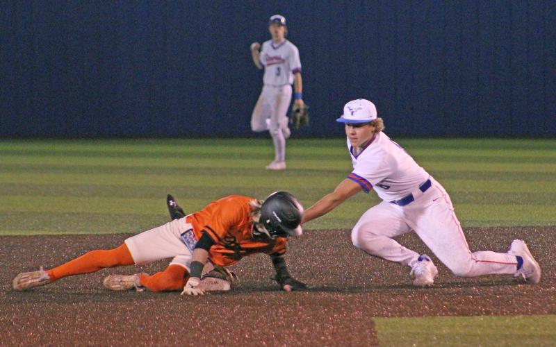 (TC GORDON | THE GRAHAM LEADER) Graham junior Harison Brockway applies a tag to a Springtown baserunner during the Steers’ season-opening loss to the Porcupines this past Monday, Feb. 19.