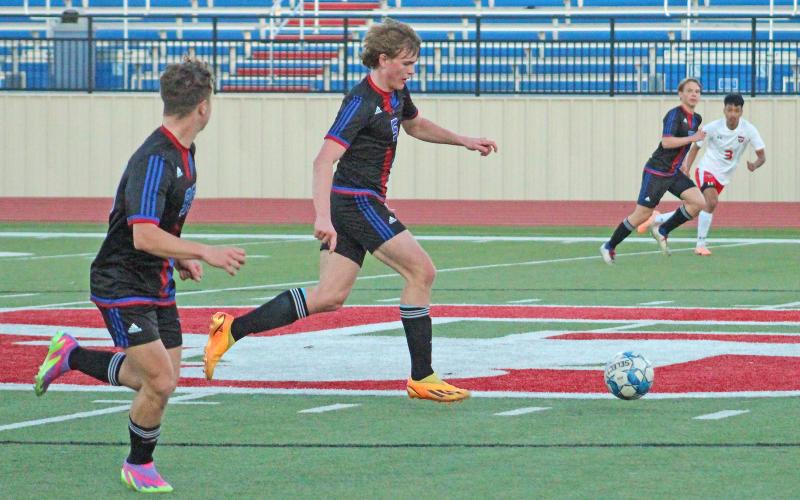 (TC GORDON | THE GRAHAM LEADER) Graham freshman Thomason Burkett (5) brings the ball across midfield with teammate Easton Hedge (99) to his side. The Steers defeated the Mineral Wells Rams in penalty kicks 3-2 Monday, Feb. 5 for their first district win.