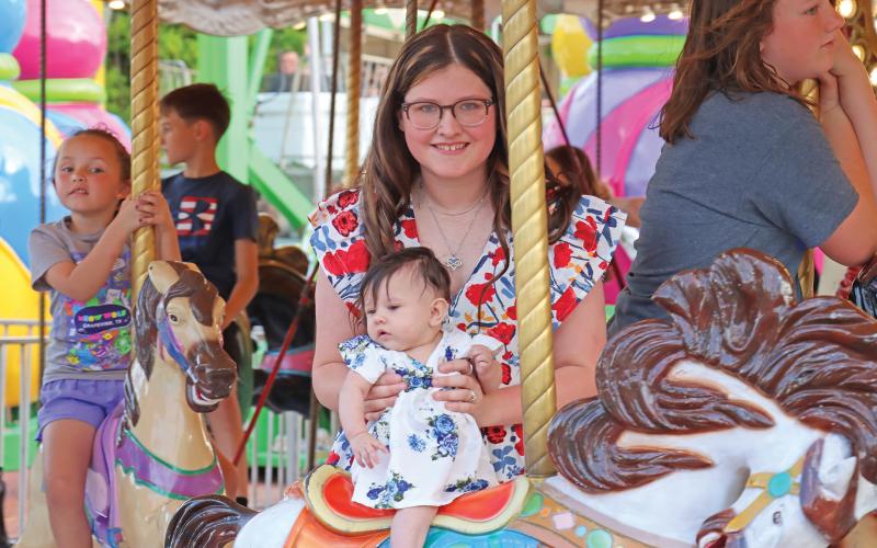 (ARCHIVE PHOTO | THE GRAHAM LEADER) Visitors to the Graham Lions Club Carnival in 2024 ride the merry-go-round on the downtown square. The carnival will be held in the same location May 7-10 opening each day at 5:30 p.m.