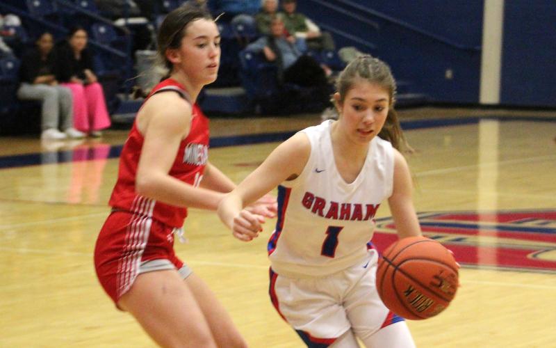 (TC GORDON | THE GRAHAM LEADER) Senior Madi Wilde (1) drives around a Mineral Wells defender during Graham’s Senior Night game against the Lady Rams last Friday, Jan. 19. The Lady Blues took a tough 22-19 loss.