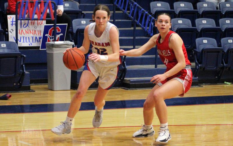 (TC GORDON | THE GRAHAM LEADER) Graham senior Hannah Williams dribbles down the baseline past a Mineral Wells defender Friday, Jan. 19 during Senior Night. The Lady Blues fought hard but took a loss 22-19.