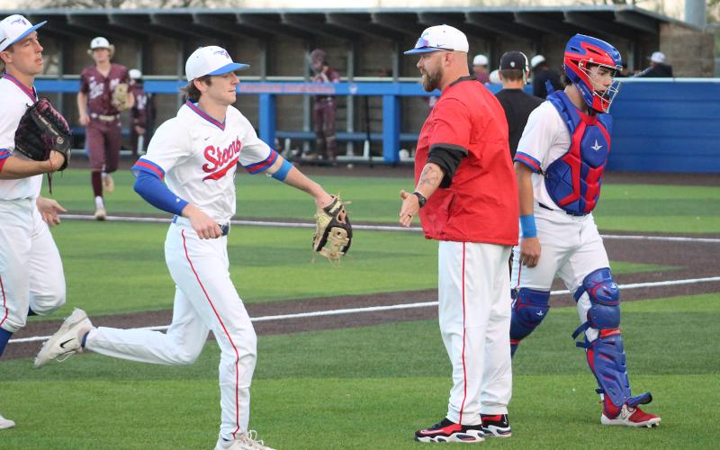 (TC GORDON | THE GRAHAM LEADER) Graham head coach Allen McGee high-fives his players as they come off the field after a strong defensive inning during one of the team’s games earlier this season. The Steers fell 4-3 to Stephenville last Thursday, March 28 in a pitcher’s battle.