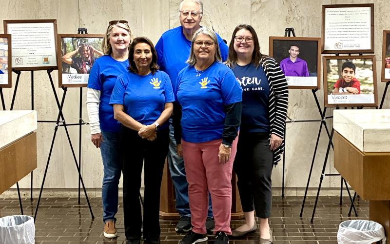 (ISABEL SMITH | CONTRIBUTED PHOTO) Members of the Young County Child Welfare Board and Heart Gallery of Northwest Texas stand Wednesday, Oct. 29 next to a Heart Gallery at Ciera Bank. Galleries are also located at the Young County Courthouse and Interbank.