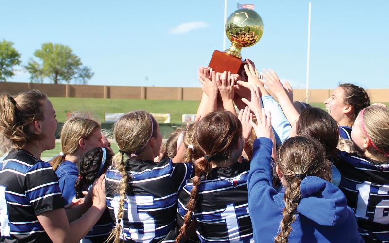 (ARCHIVE PHOTO | THE GRAHAM LEADER) The Lady Blues lift the bi-district trophy up and celebrate together after defeating Borger in a bi-district matchup Monday, March 25. The win was the Lady Blues’ first playoff victory in the program’s history as they beat the Lady Bulldogs 4-3 in a penalty kick shootout.