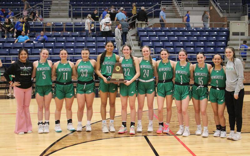 (TC GORDON | THE GRAHAM LEADER) The Newcastle Ladycats stand with their Region 3 championship trophy Saturday, Feb. 24 after they defeated Dodd City 55-26 to advance to the state tournament in San Antonio. The Ladycats will take on Westbrook in the first semifinal Thursday, Feb. 29 at 8:30 a.m.