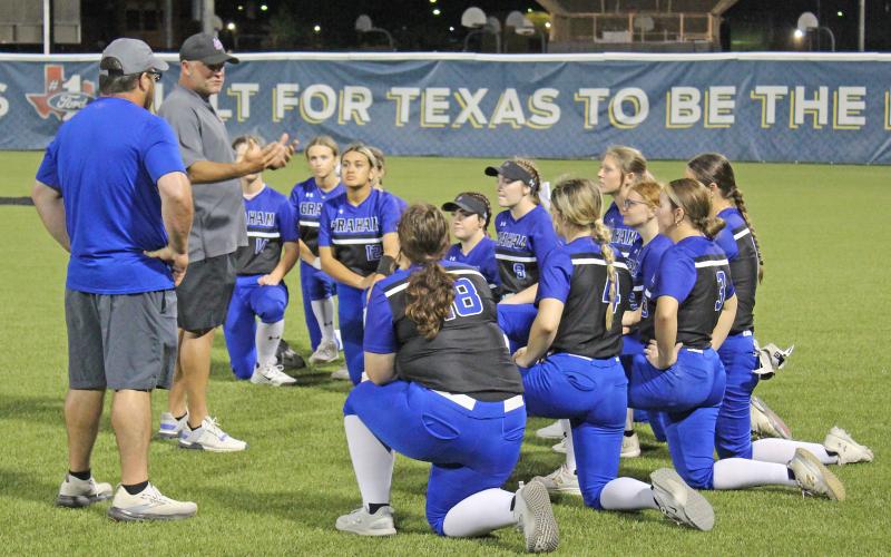 (TC GORDON | THE GRAHAM LEADER) Head coach Adam Arrington (second from left) addresses the Lady Blues following their defeat to Burkburnett in the area round of the playoffs. The Lady Blues finished the year with a 24-10 record, which included a regular season district championship and a bi-district playoff championship.