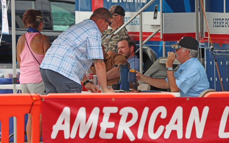(THOMAS WALLNER | THE GRAHAM LEADER) Members of American Legion Post 34 speak with visitors at the Mobile Vet Center from Abilene which was at the Food Truck Championship of Texas held Saturday, June 7 in Graham.