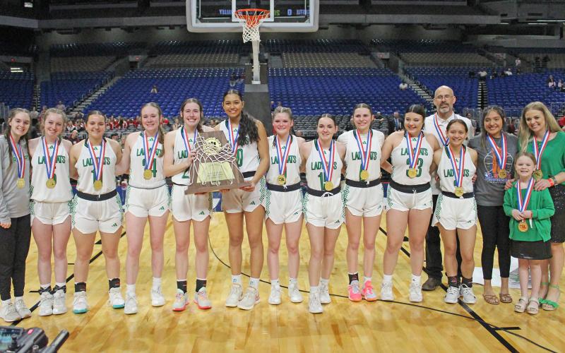 (TC GORDON | THE GRAHAM LEADER) The Newcastle Ladycats stand with their Class 1A state championship trophy Saturday, March 2 after they defeated the Turkey Valley Lady Patriots 48-32 to claim the title.