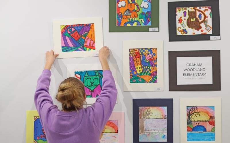 (THOMAS WALLNER | THE GRAHAM LEADER) Students from Graham High School helped put up artwork from Graham ISD, Jacksboro ISD, Bryson ISD and Archer City ISD at the Old Post Office Museum and Art Center.