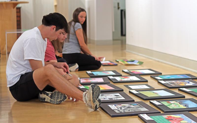 (THOMAS WALLNER | THE GRAHAM LEADER) Graham High School students look over artwork from Graham and area schools that is on display in an exhibit at the Old Post Office Museum and Art Center. The exhibit is a celebration local artists for Youth Art Month.
