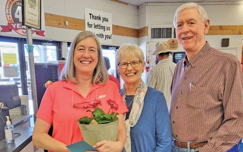 (SAMANTHA WINDER | CONTRIBUTED PHOTO) Curtis and Geneva Buchanan take a photo with Kris Camp at Buchanan Building Supply. The store will be celebrating 75 years of operation in November.