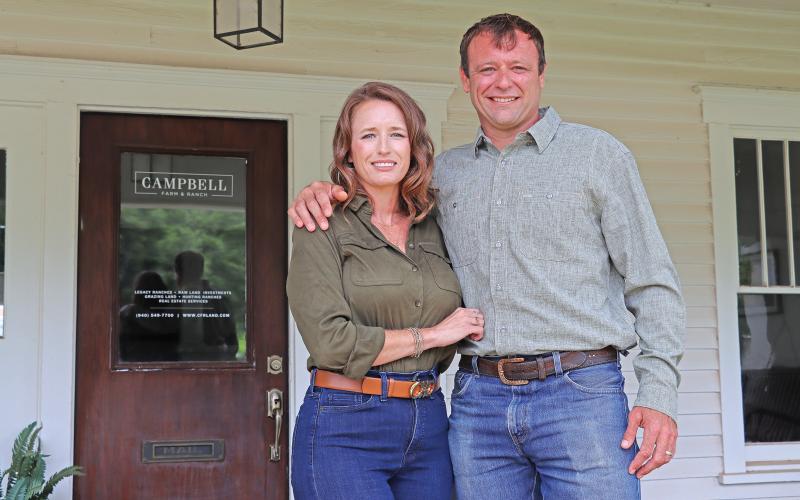 (THOMAS WALLNER | THE GRAHAM LEADER) Stephanie and Boone Campbell stand in front of their business Campbell Farm & Ranch on Elm Street in Graham. The company and Boone Campbell recently received multiple accolades for their work rural real estate industry.